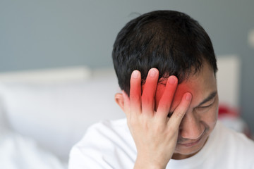 man clutching head in pain